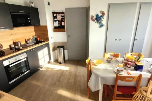 une cuisine avec une table et des chaises ainsi qu'une cuisine avec une cuisinière dans l'établissement 