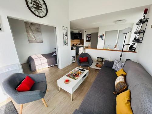 een woonkamer met een bank, 2 stoelen en een tafel bij "LA PERLE MARINE" Appartement, 4 personnes, balcon, vue mer et port de plaisance in Talmont