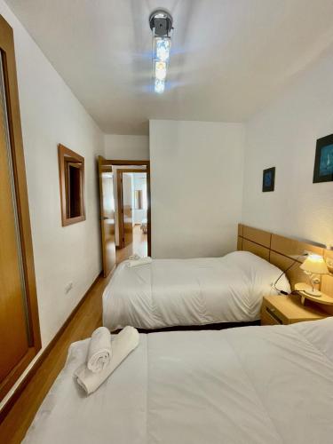 a hotel room with two beds with white sheets at Apartment Costa Azahar II Ref 012 in El Borseral