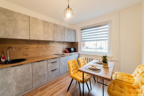 een keuken met een tafel en 2 stoelen bij A.P. Yellow Apartment in Šiauliai