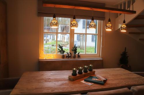 a wooden table with candles on it in front of a window at HaffSide Usedom in Zirchow