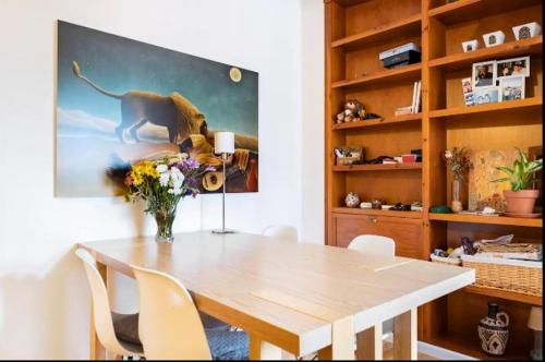 un tavolo da pranzo con sedie e un vaso di fiori di Acogedora Habitacion en apartamento compartido amplio y céntrico a Granada