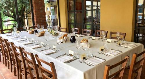 une grande table avec un tissu de table blanc et des chaises dans l'établissement CASCINA DOMINA, à Gassino Torinese