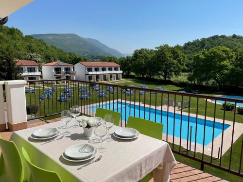 einen Tisch mit Weingläsern auf einem Balkon mit Pool in der Unterkunft Bran Nature&Relax in Costermano sul Garda