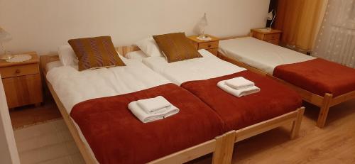 two beds in a room with white and red blankets at domek jelenia góra in Jelenia Góra