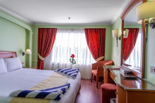 a hotel room with a bed and a window at Monte Carlo in Nag` Naqsha