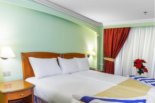 a hotel room with a large white bed and a window at Monte Carlo in Nag` Naqsha