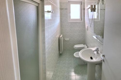 ein weißes Bad mit einem WC und einem Waschbecken in der Unterkunft Bran Nature&Relax in Costermano sul Garda