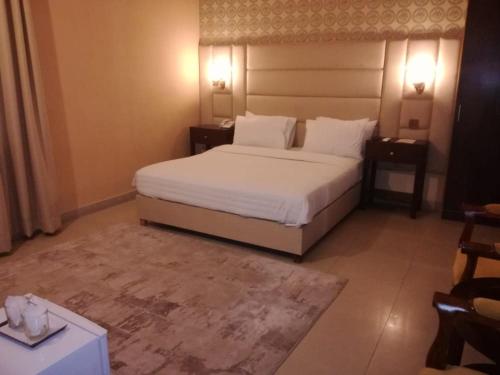 a bedroom with a large bed and two night stands at R.M RESIDENCY in Lahore