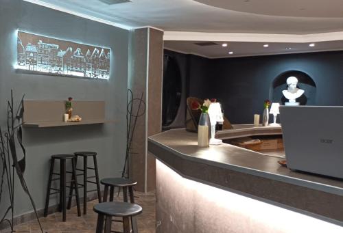 un bar avec tabourets et un comptoir avec miroir dans l'établissement Hotel The Marins, à Bra