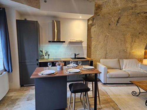 a kitchen and living room with a table and a couch at Charmante maison troglodyte Loire Valley in Rochecorbon