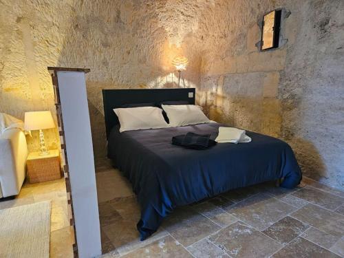 um quarto com uma cama com um edredão azul em Charmante maison troglodyte Loire Valley em Rochecorbon