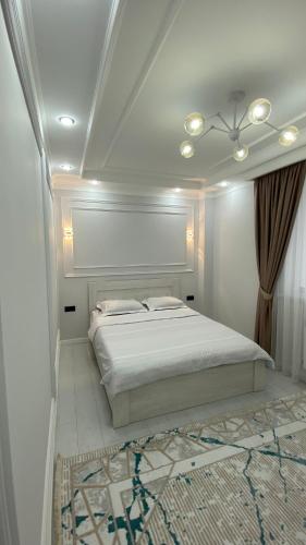 ein weißes Schlafzimmer mit einem großen Bett in einem Zimmer in der Unterkunft Br group in Schymkent