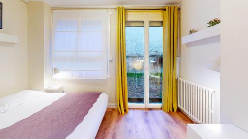 une chambre avec un lit et une grande fenêtre dans l'établissement Le p'tit Flaubert- Quartier Coty, au Havre