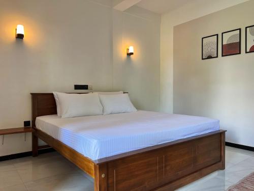 a bedroom with a large bed with white sheets at Seek the Sun in Matara