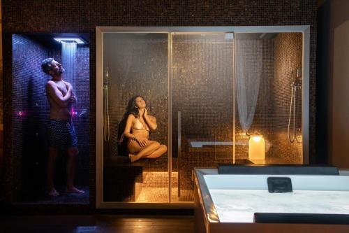 a woman is sitting in a shower in a bathroom at The Spring House Hotel Rome Vatican, Tapestry Collection Hilton in Rome