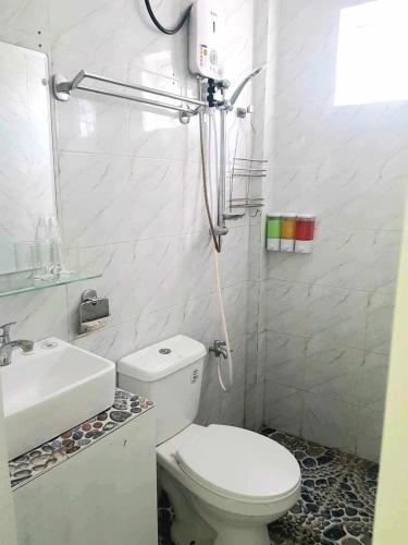 サマルにあるDeiHouseのトイレと洗面台を備えた白いバスルーム