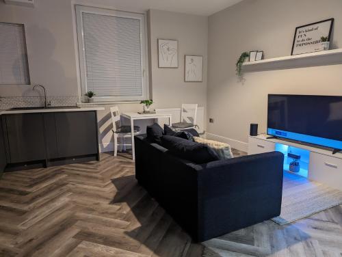 a living room with a couch and a flat screen tv at Wellington Circus in Nottingham