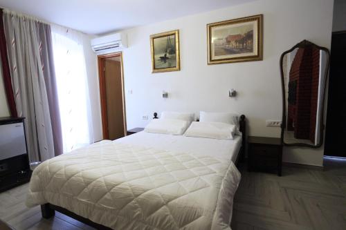 a bedroom with a white bed and a mirror at Golden Gate Dream Rooms in Split