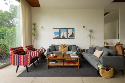 a living room with a couch and chairs and a table at La Meira 3BHK Villas in Assagao with Private Pool, Garden, Caretaker, Kitchen & Security in Vagator