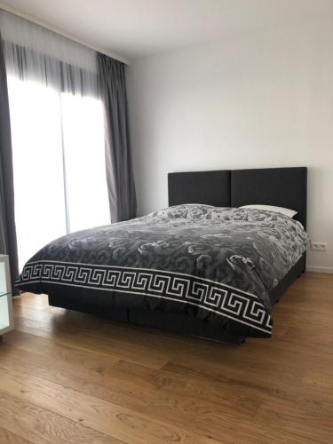 a bedroom with a bed with a black and white comforter at Studio de standing in Malakoff