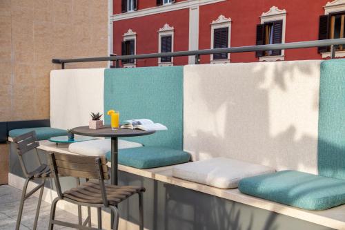 a table and chairs on the balcony of a building at The Spring House Hotel Rome Vatican, Tapestry Collection Hilton in Rome