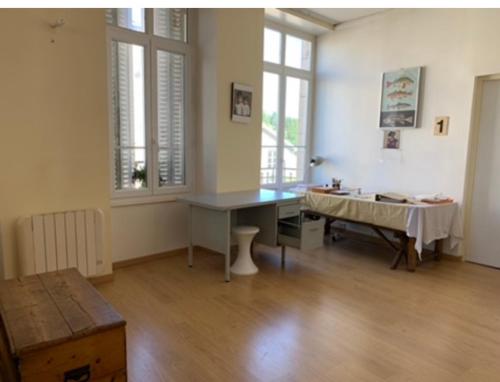 una grande camera con scrivania e tavolo di Chambre privée 2 personnes a Bourganeuf