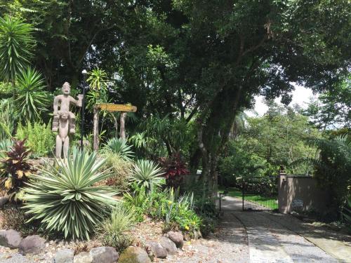 a statue of a man standing in a garden at Cabanas Rio Encantado in Alto Boquete