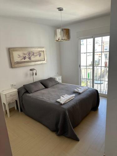une chambre avec un lit, une table et une fenêtre dans l'établissement Trevlig lägenhet i City Nerja, à Nerja