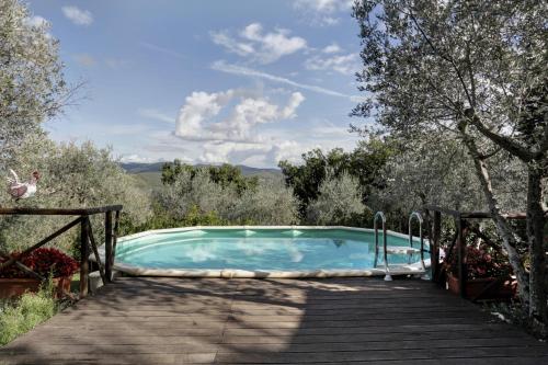 a swimming pool on a wooden walkway next to a wooden deck at Villa Sofia Eden & Spa in Gaiole in Chianti