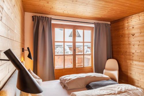 a bedroom with a bed and a window at Chalet Flocke Appart Murmeltier in Sankt Anton am Arlberg
