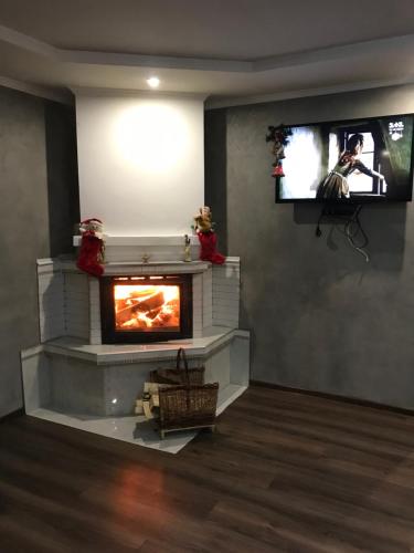 a living room with a fireplace and a flat screen tv at «У полоні гір» in Verkhovyna
