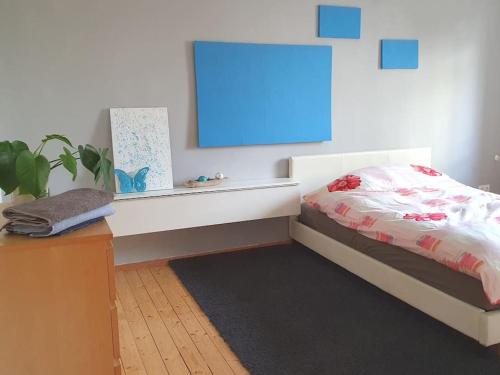 um quarto com uma cama, uma mesa e uma tábua azul em 4 Zimmer Wohnung zentral in Osnabrück em Osnabrück