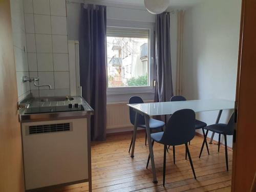 uma cozinha com uma mesa e cadeiras e um lavatório em 4 Zimmer Wohnung zentral in Osnabrück em Osnabrück