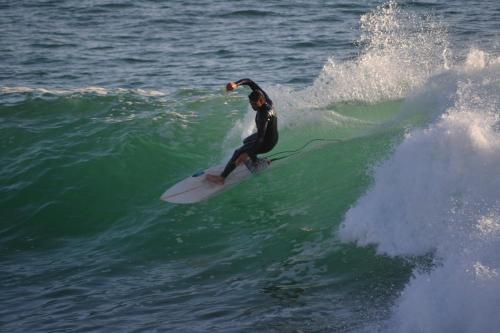 a man riding a wave on a surfboard in the ocean at Paddle Out Morocco in Tamraght Ouzdar
