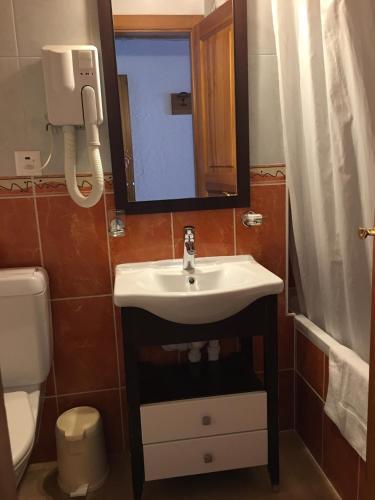 a bathroom with a sink and a toilet and a mirror at Residence Panorama in Villars-sur-Ollon