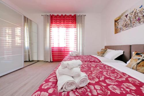 a bedroom with a red and white bed with towels on it at Tranquillità Centrale - Vicino Spiaggia e Aeroporto in Fiumicino