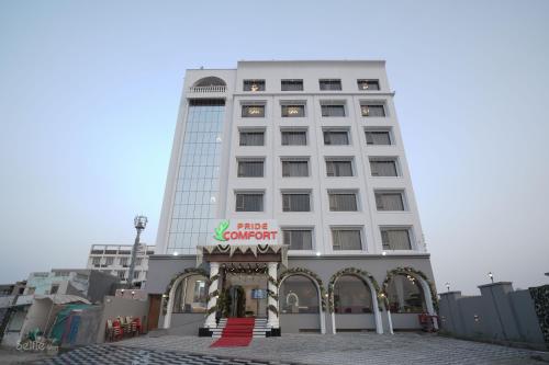 a white building with a first court sign in front of it at Pride Comfort Dwarka in Dwarka