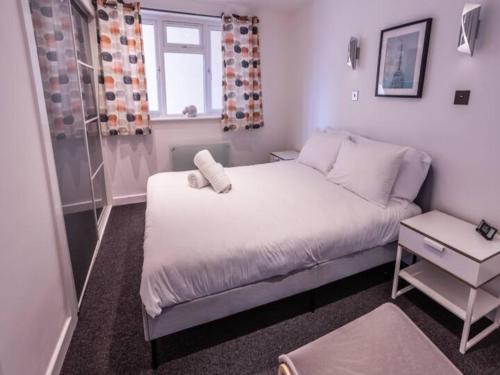 niewielka sypialnia z białym łóżkiem i oknem w obiekcie Newly renovated ideally situated 2 bedroom flat w Bournemouth