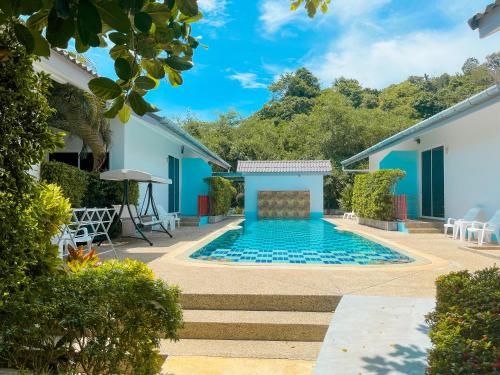 a swimming pool in the middle of a yard at Rawai Valley Resort in Rawai Beach