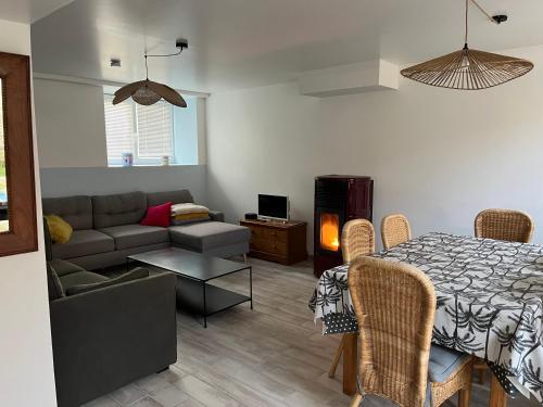 un salon avec un lit, un canapé et une table dans l'établissement Le gîte de la rue, à Gréville-Hague