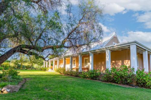 una casa blanca con césped verde en Bella de Karoo, en Calitzdorp