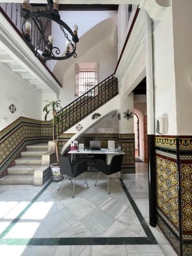 sala de estar con escalera y piano en Hostal Atenas, en Sevilla