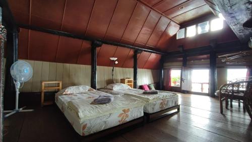 a bedroom with two beds in a room at Romlan in Tuk Tuk