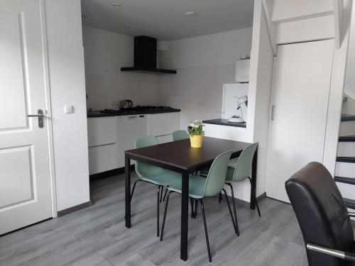a dining room table and chairs in a kitchen at Modern zomerhuis voor 4 personen in Wijk aan Zee