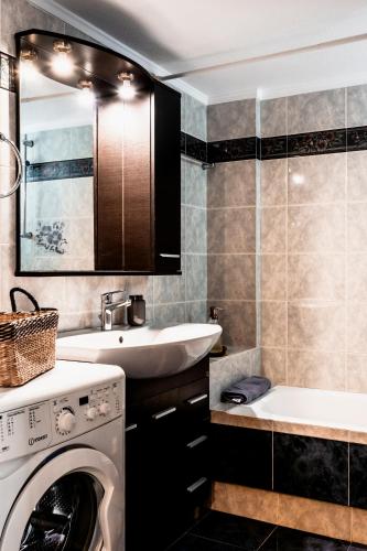 a bathroom with a washing machine and a sink at Va Yia/ Spacious guest house in Nafplio