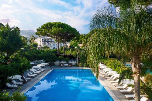 a swimming pool with lounge chairs and a resort at Grand Hotel Cocumella in Sant'Agnello