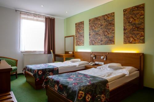 a hotel room with two beds and a window at Hotel Max Inn in Bratislava