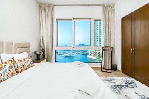 um quarto com uma cama e uma grande janela em Sea and Atlantis View 3 BR Apartment Palm Jumeirah em Dubai