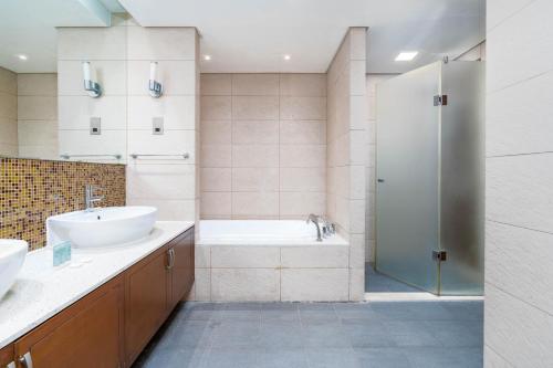 uma casa de banho com uma banheira, um lavatório e um chuveiro em Sea and Atlantis View 3 BR Apartment Palm Jumeirah em Dubai